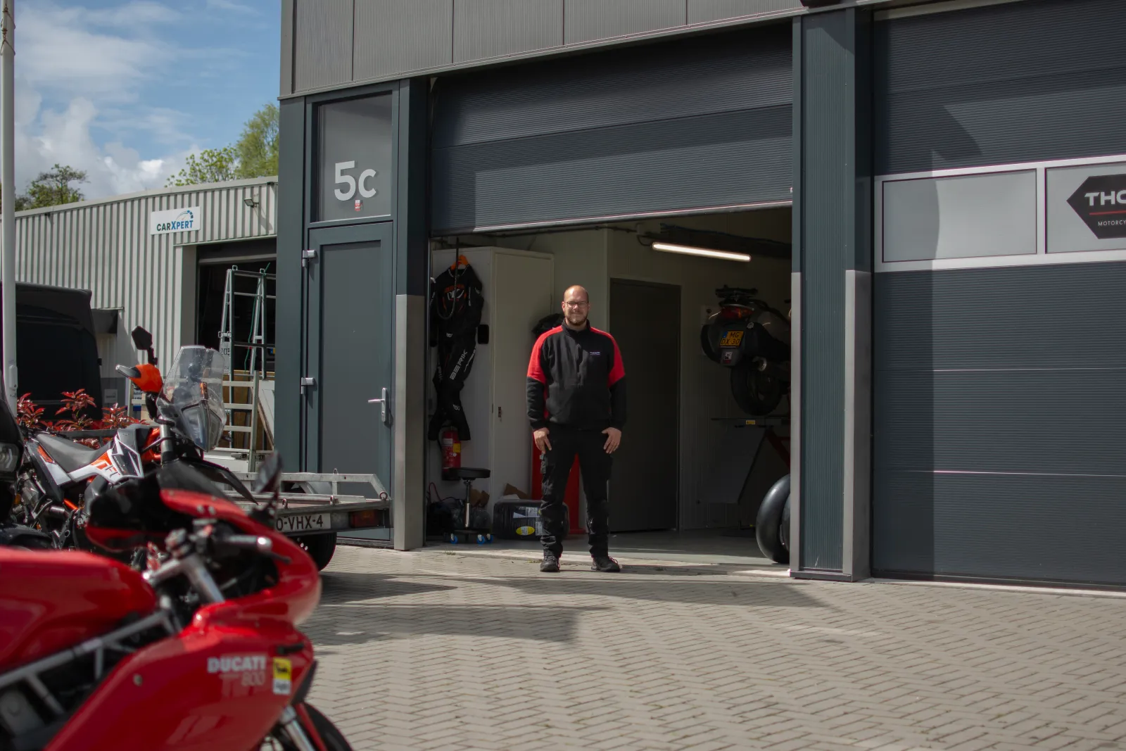 Thomas Haagsma voor Thom's Motorcycle Garage met een Ducati op de voorgrond